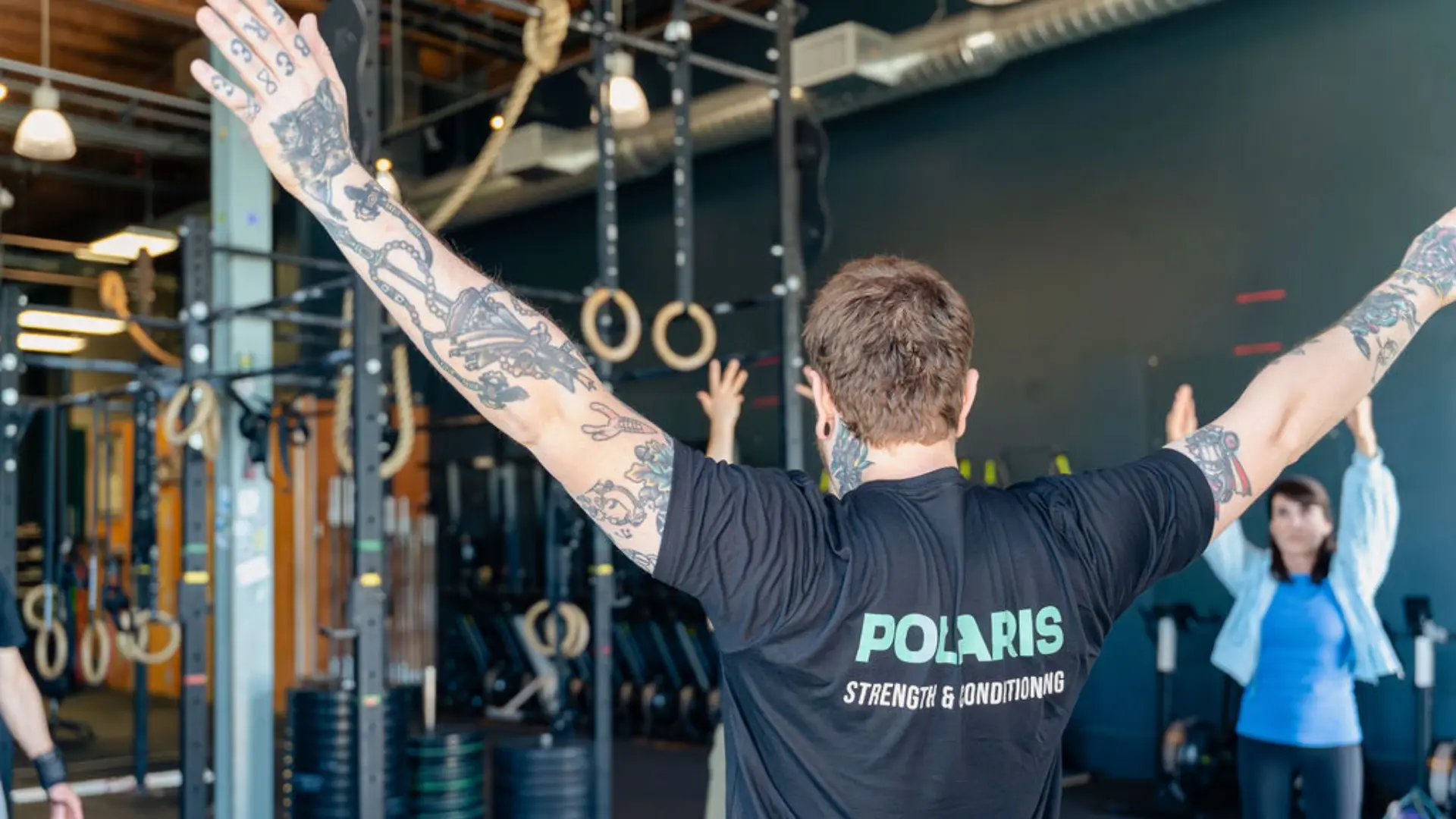 A Polaris member carrying dumbbells during a strength training session