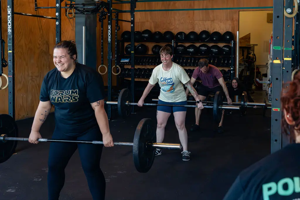 Members lifting barbells in a small group strength training session at Polaris in Seattle
